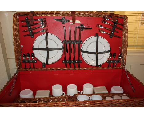 An Asprey, London, wicker picnic hamper with eight settings, including thermos, containers, glasses, plates, cutlery etc