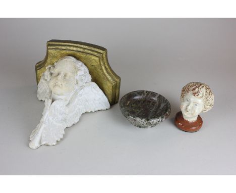 A ceramic wall bracket with cherub support, a porcelain cherubic head and a polished stone bowl