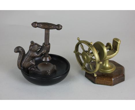A bronzed metal squirrel nutcracker together with a brass nutcracker shaped as a ship's wheel