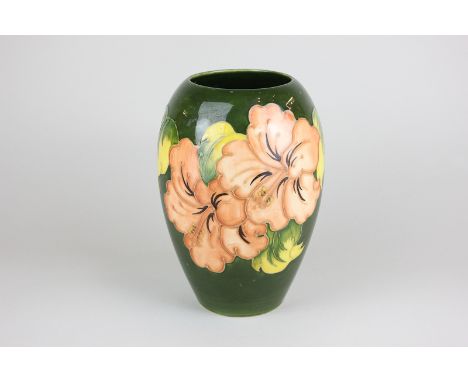 A Moorcroft hibiscus pattern vase, circa 1960, in pink and peach on dark green ground, 18cm high