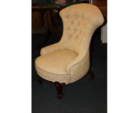 A button back nursing chair in cream jacquard upholstery on curved legs and castors