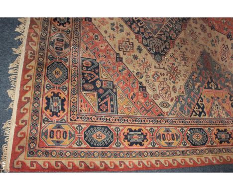 A Hamadan wool carpet with three central diamond motifs surrounded by geometric borders, in cream orange and blue 272cm by 37