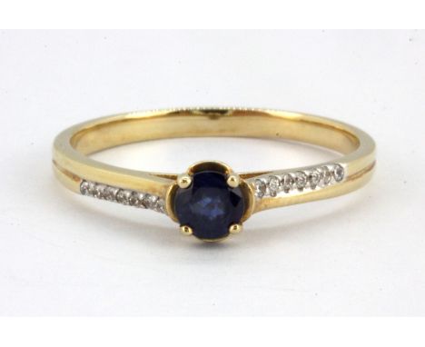 A 14ct yellow gold (stamped 585) sapphire set solitaire ring with diamond set shoulders, (Q).