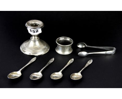 A hallmarked silver candlestick, silver napkin ring with four silver coffee spoons and sugar tongs.