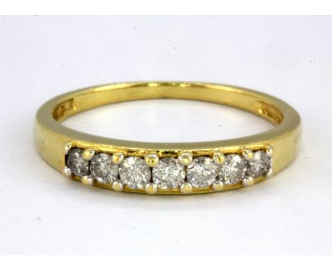 An 18ct yellow gold (stamped 18k) diamond set half eternity ring, (N.5).