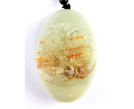 A Chinese carved white and russet jade pebble with onyx and wood bead carrying handle, pebble H. 8.5cm