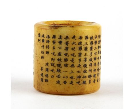 A Chinese carved bone thumb ring decorated with characters.