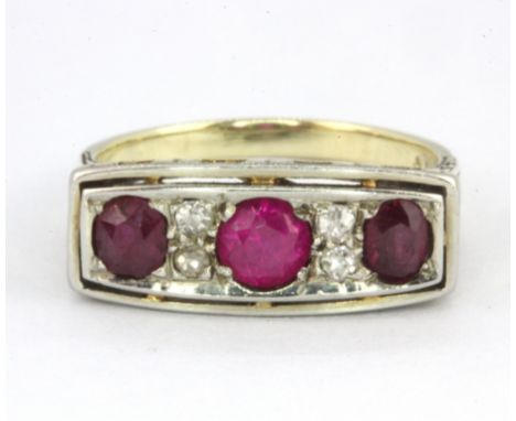 A 14ct yellow and white gold (stamped 14k) ring set with three old cut rubies and diamonds, (K).