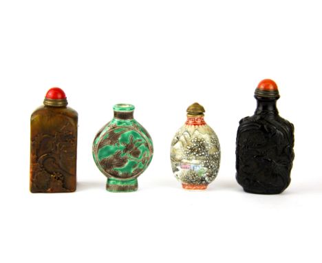 A group of four Chinese snuff bottles, including two porcelain, one carved stone with seal base and one glass, tallest 8cm.