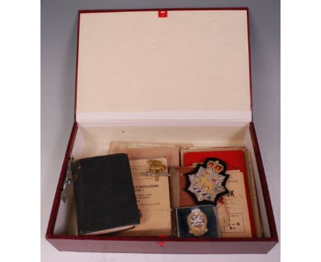 A collection of assorted military ephemra and effects to include Queens Regiment cap badge and buckle, together with Regular 