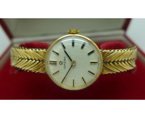 A lady's 9ct gold Omega manual wind wristwatch, 19mm diameter, with integral 9ct gold bracelet strap,working. Comes with box 