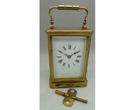 A brass four-glass sided carriage clock, gong striking French movement with brass key. Height 125cm