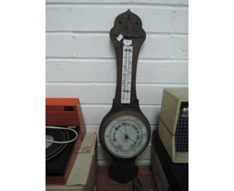 A vintage wooden cased barometer having white glass face dial