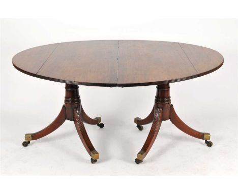 A large 19 th century mahogany twin pedestal dining table, with fluted borders above turned collared columns, each raised on 