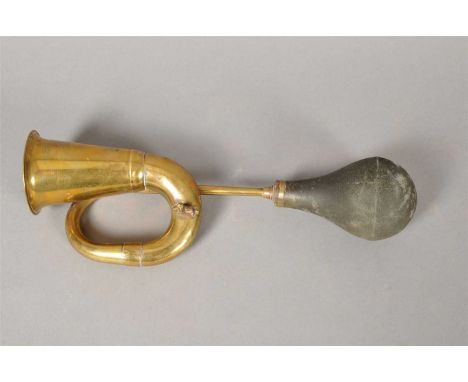 An Edwardian brass automobile horn, of conical form with a flared rim before a black rubber bulb, 33 cm long.