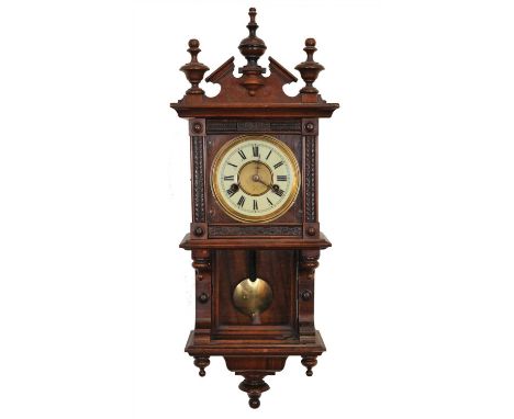 A small 19th century mahogany cased wall clock, with a disk dial populated with black Roman numerals, fitted in an architectu