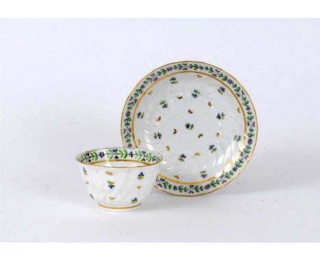 A Caughley tea bowl and saucer circa 1780-85, of spiral fluted form painted in polychrome with French Sprigs between double c