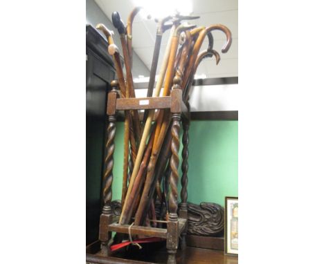 A collection of walking sticks, a stick stand, an elm seated chair and a spinning wheel  