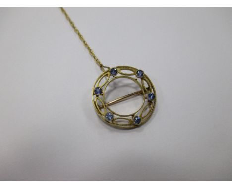 A small round five stone sapphire brooch, stamped 15ct to reverse, set with safety chain, 2.3cm diameter  