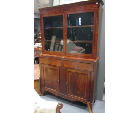 A Regency mahogany china display cabinet, with ebony husk inlays to the doors above two drawers and two cupboards, on swept b