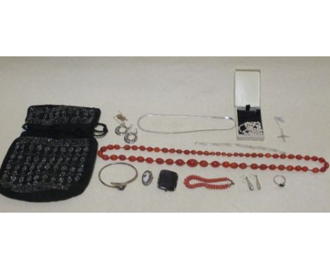 An evening bag containing a flurospar brooch, a cornelian bead necklace, a graduated pearl necklace, a silver and pearl ring 