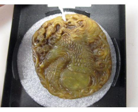 A Chinese jade roundel carved with a phoenix  