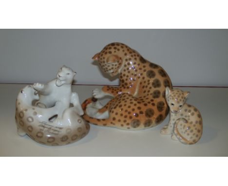 Three Lomonosov leopard groups, the largest playing with its tail, 19cm, the pair playing and dated 1964, 15cm high and the s