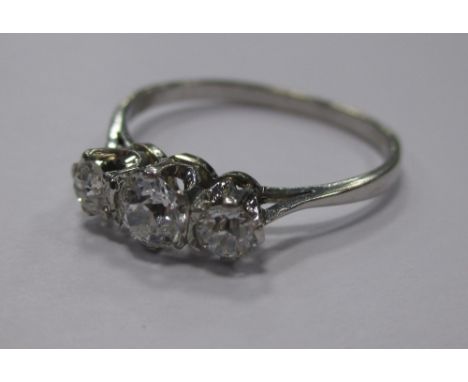 A three stone diamond and platinum ring, the three graduated stones all claw set to a plain band stamped 'PLAT', total estima