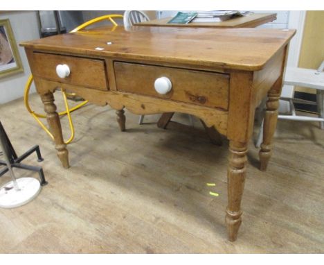 A two drawer pine side table with white ceramic handles, 76 x 118 x 64cm  