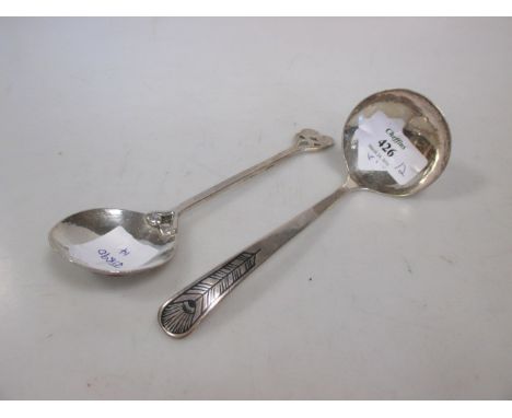 An arts and crafts spoon and a small silver ladle  