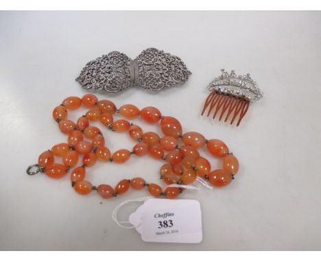 A graduated strand of oval cornelian beads, a silver buckle and a paste set hair comb (3)  