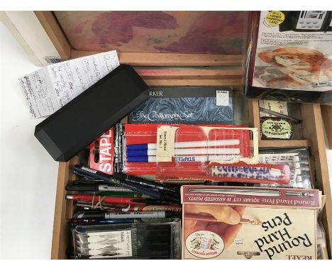 A boxed table easel, sketch pads and two wooden artist boxes containing brushes, pens and wooden models.