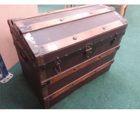 A domed top wood bound travel trunk.