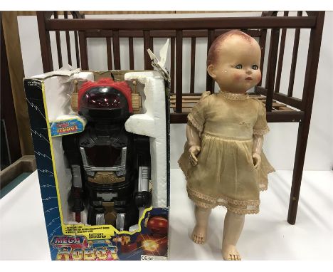 A child's cot, doll and a Mega Robot.
