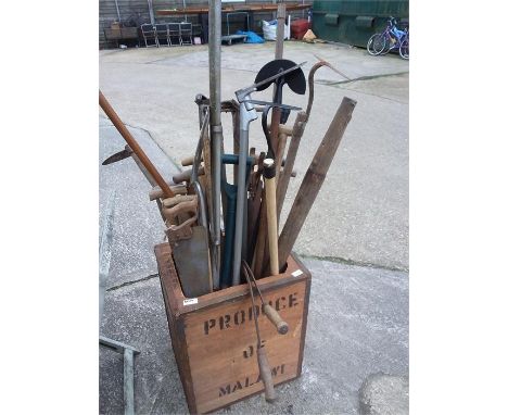 A tea chest full of garden tools.