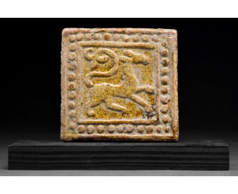 Ca. 1300–1500 AD. Persian, probably Kashan. A beautiful tile of rectangular form, decorated in yellowish lustre with a beast 