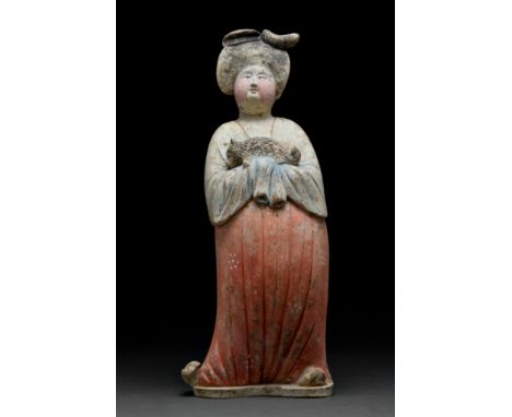 Ca. 618–907 AD. Chinese Tang Dynasty. This elegant court lady stands on a flat base. Her hands are held close to her body and