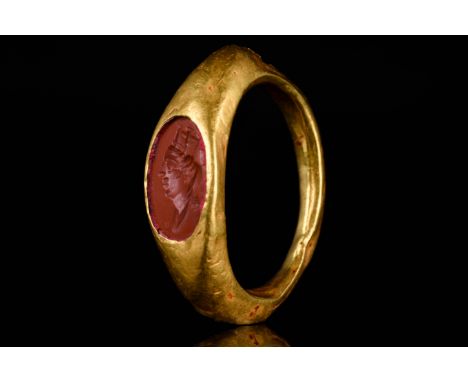 Ca. 200–300 AD. Roman. A beautiful gold ring with a hollow circular band, flared shoulders, and an ellipsoidal bezel inset wi