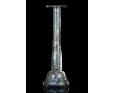 Ca. 100–300 AD. Roman. A beautiful pale dark blue glass candlestick unguentarium with an out-turned rim, cylindrical neck, an