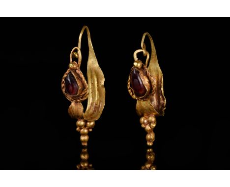 Ca. 100–200 AD. Roman. A matched pair of gold earrings, each comprising a curved, leaf-shaped hoop tapering at one hand, a cl