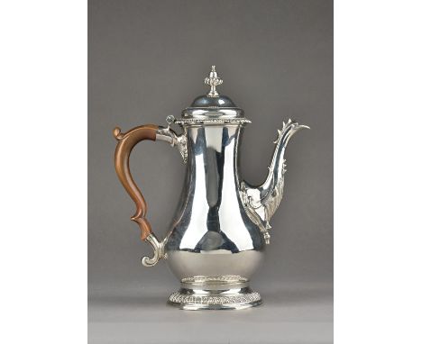 An early George III silver coffee pot, of baluster form, decorated with gadrooned rims, with a fluted acorn shaped finial, fi