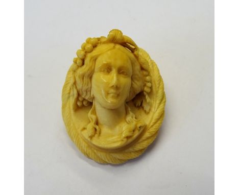 A Victorian carved ivory cameo brooch, designed as the portrait of a bacchante, with fruiting vine within a ropetwist border.