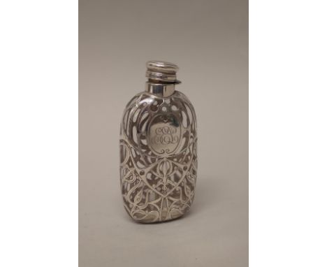 An American silver mounted glass spirit flask, with engraved scrolling decoration and monogram engraved. 