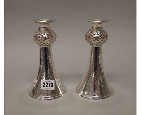 A pair of silver table candlesticks, each of flared trumpet shaped form, with a pierced bulbous stem above a flared circular 