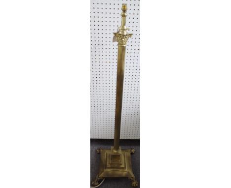 A Victorian brass adjustable standard lamp of Corinthian column form raised on a stepped square base and four lion paw feet. 