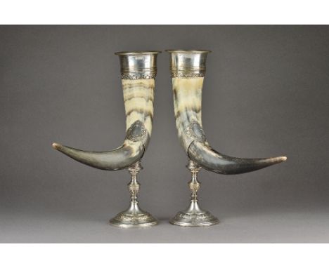 A pair of silver plated metal mounted horn table ornaments, each with scroll and floral decoration to the mounts and raised o