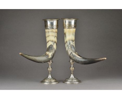 A pair of silver plated metal mounted horn table ornaments, each with scroll and floral decoration to the mounts and raised o