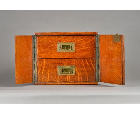 A Victorian brass mounted oak table cabinet, the pair of doors enclosing a pair of drawers, 30cm wide x 25cm high. Illustrate