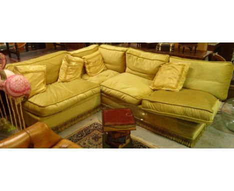 An early 20th century mahogany framed corner sofa with green upholstery on tapering supports, 170cm wide.