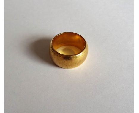 A gold wide band wedding ring, with traces of engraved decoration, detailed 22 CT, ring size K, weight 17.8 gms.